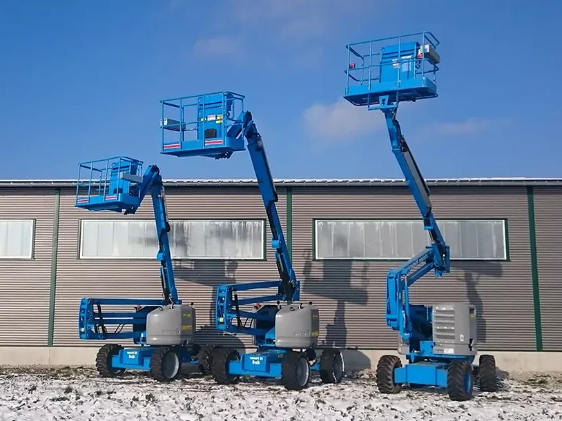 Drei blaue Teleskopbühnen vor einer Halle auf dem Firmengelände von Stöcklein Mietservice.