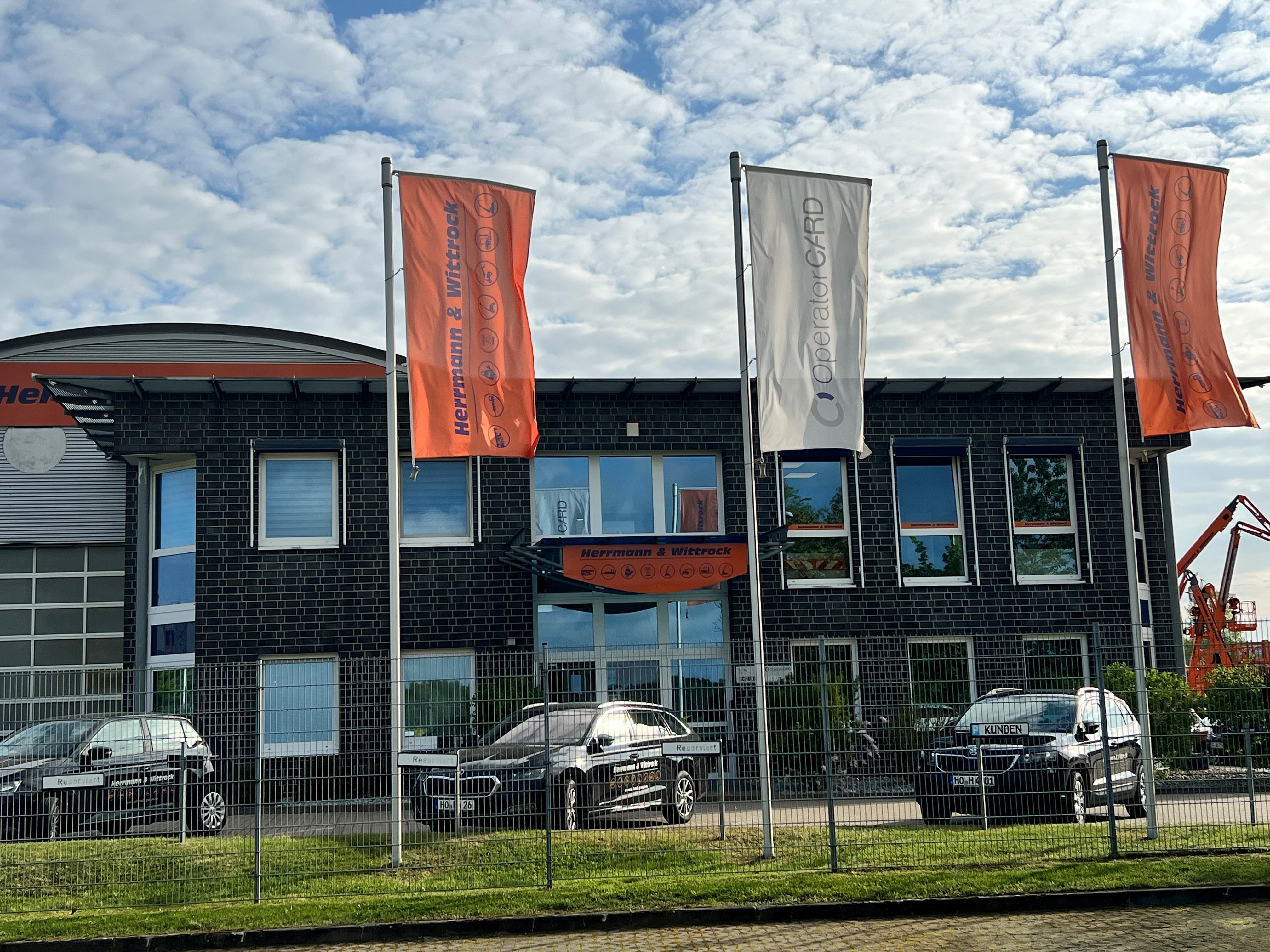 Firmengebäude von Herrmann & Wittrock der Niederlassung Groß Kienitz mit wehenden Flaggen
